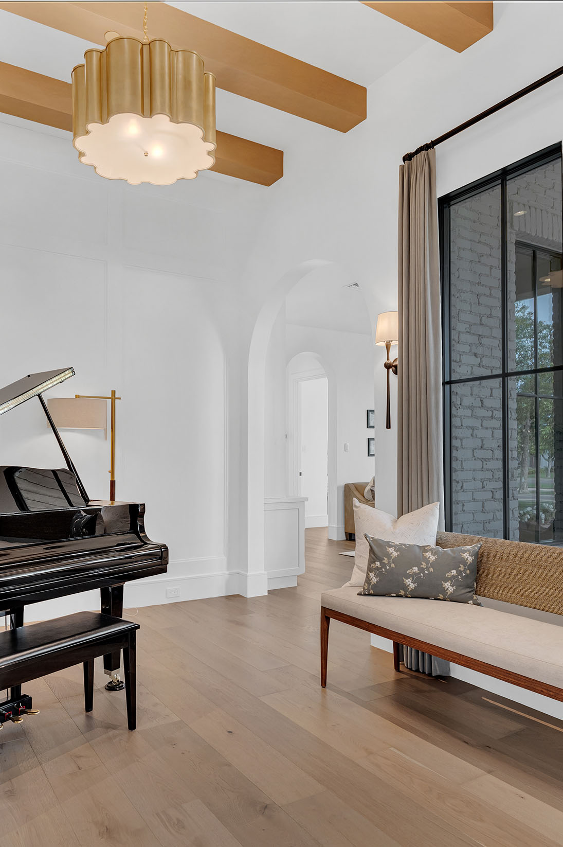 Luxury Music Room with Grand Piano and Arched Display Cabinet – A refined music room featuring a black grand piano, arched wood display cabinet, and modern gold chandelier, enhancing the elegant ambiance.