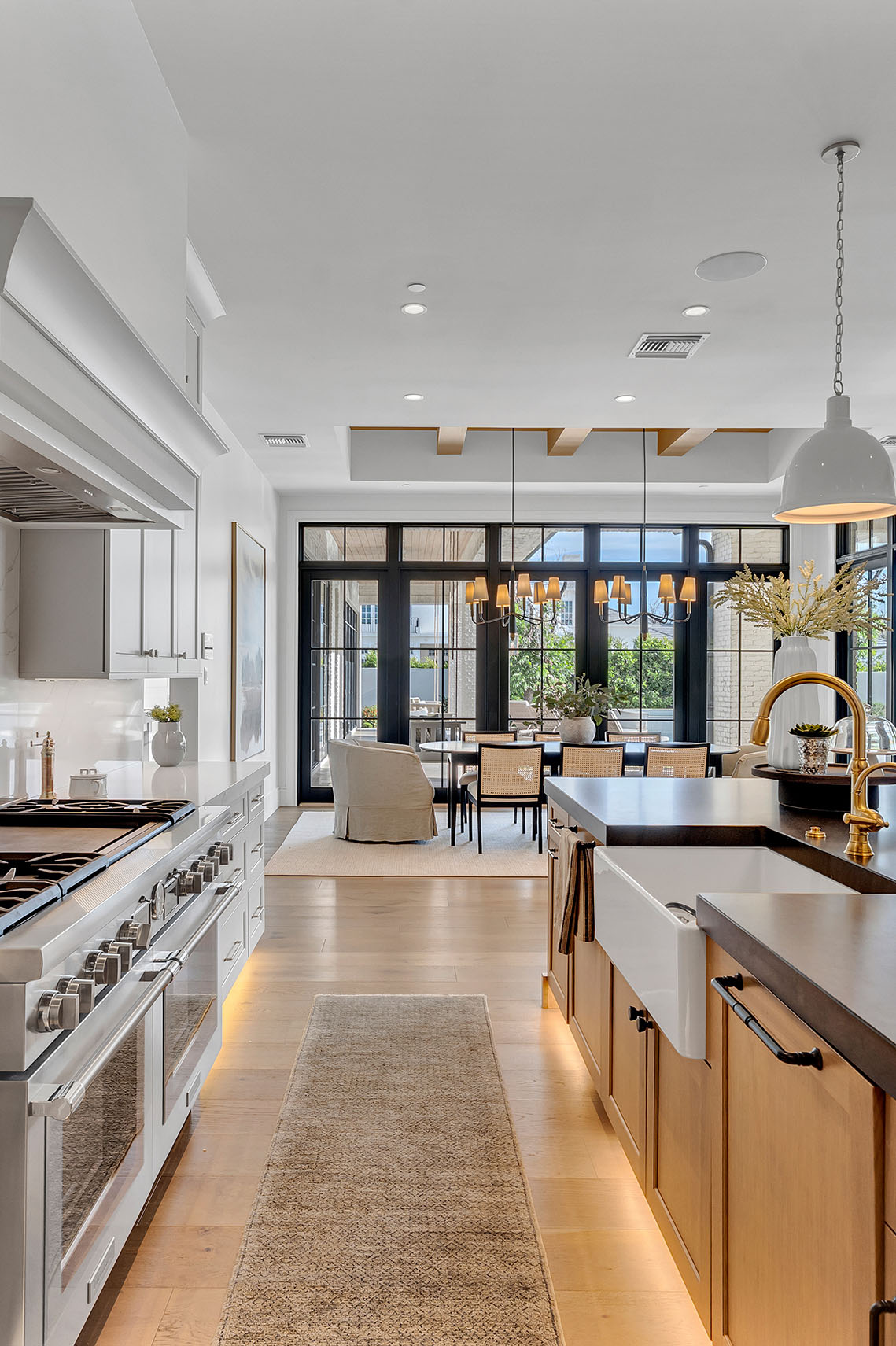 A chef’s dream kitchen with a sleek black island, brass pendant lighting, and custom cabinetry for a high-end look.