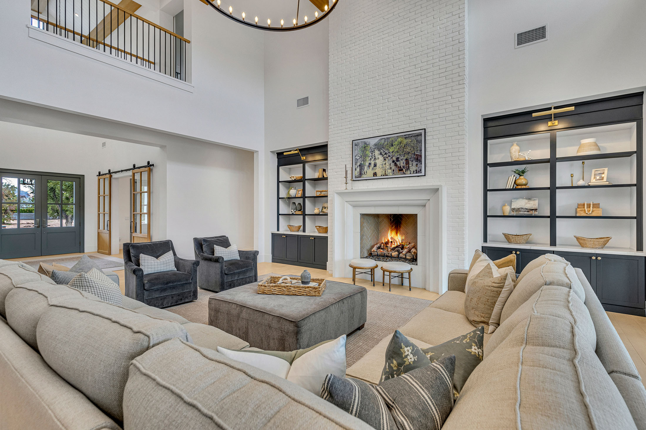 A sophisticated living area featuring a grand white brick fireplace, dark built-in bookcases, and plush seating.